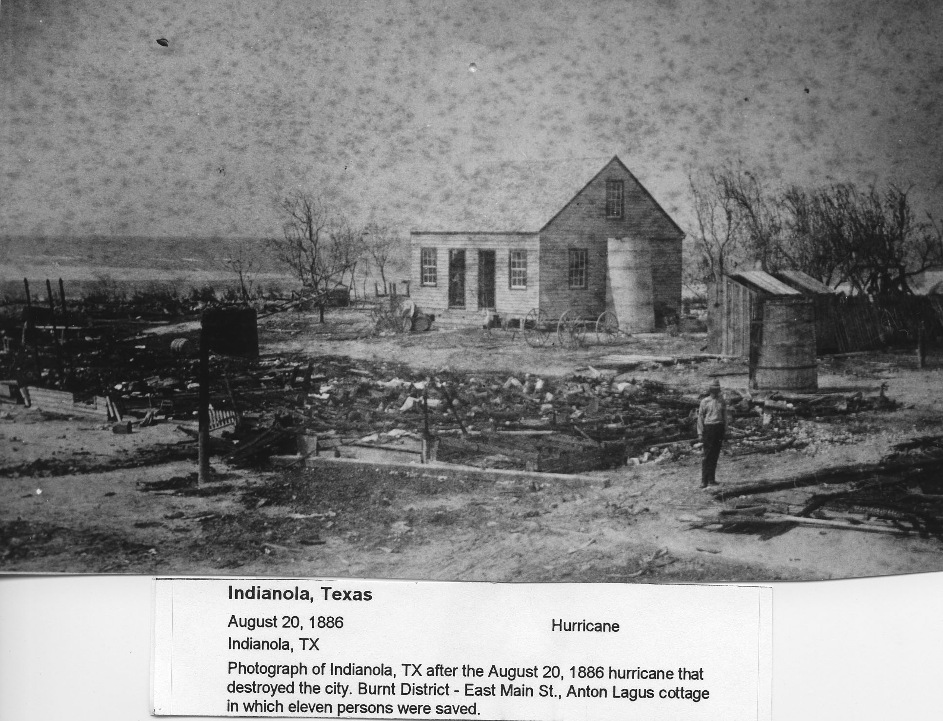 Photograph of Indianola, TX after the August 20th 1886 huricane that destroyed the city.  Burnt District - East Main St., ANton Lagus cottage in which eleven persons were saved.
